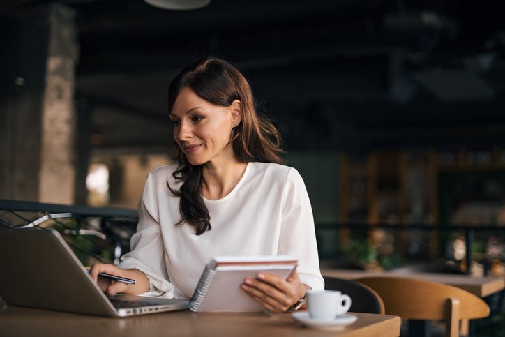 Professionista che scrive un’email in inglese per comunicare un ritardo lavorativo