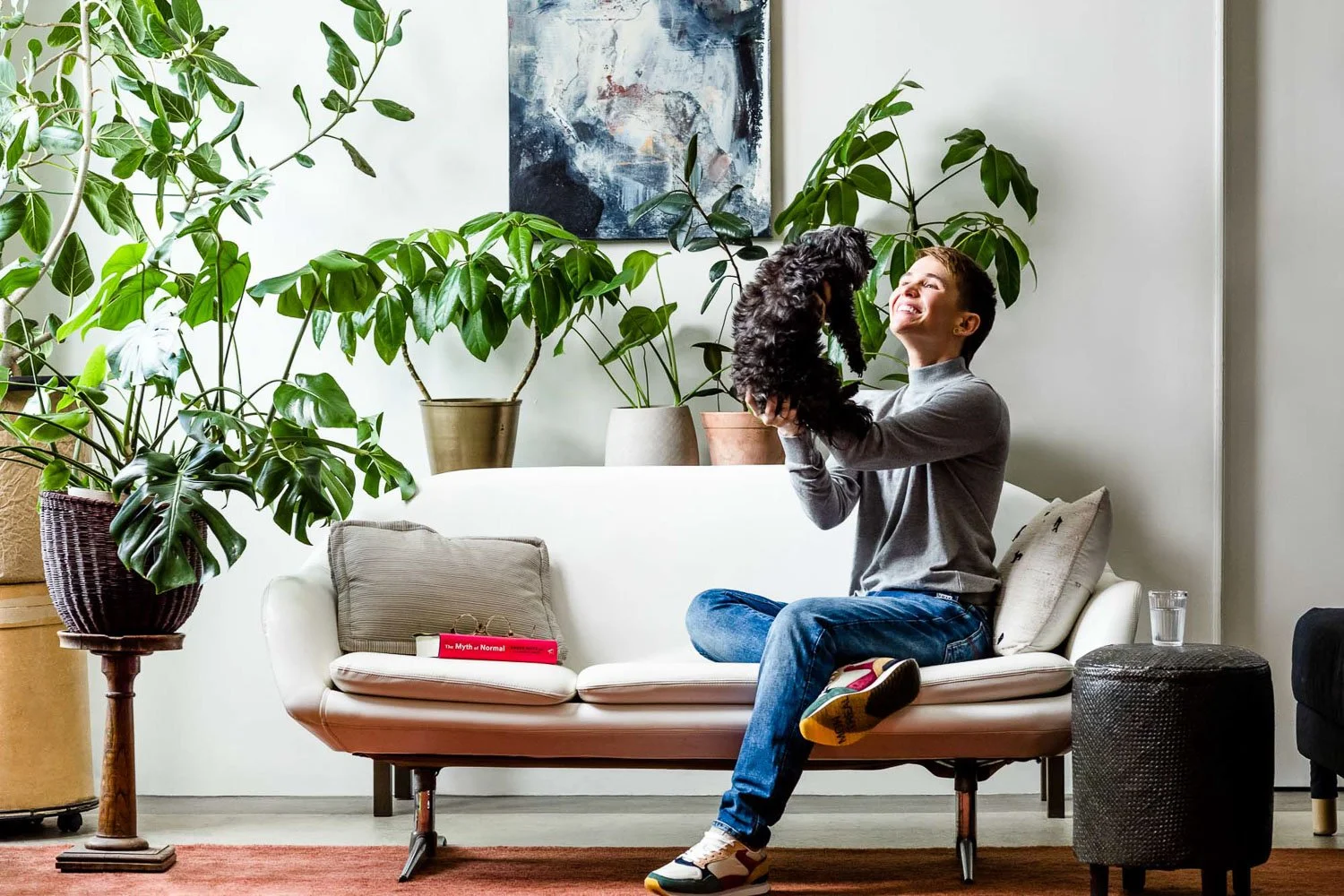 Non-binary person playing happily with dog during commercial lifestyle and personal branding shoot, San Francisco Bay Area commercial photographer