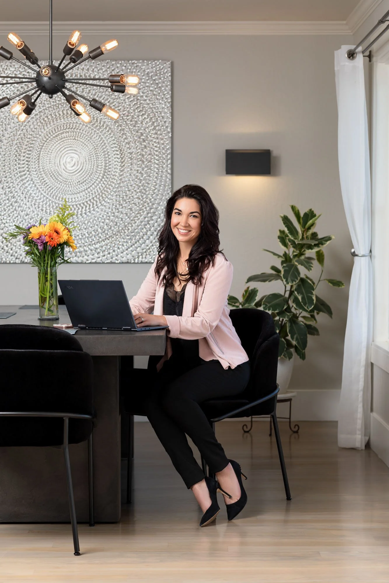 Lifestyle portrait of smiling woman in pink jacket working at home table, San Francisco Bay Area commercial lifestyle photographer