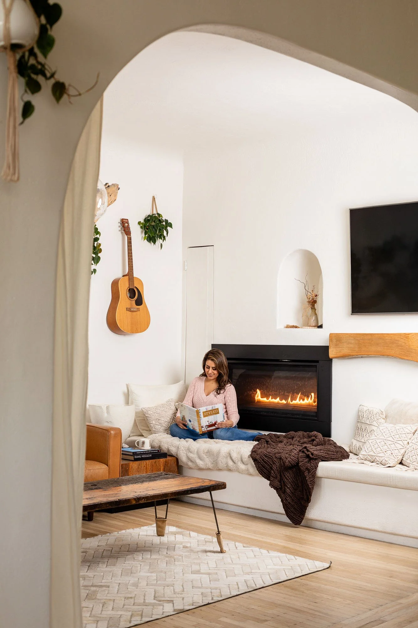 Commercial lifestyle photo of person relaxed and reading by fireplace inside San Francisco home, Bay Area lifestyle photographer for interior design home decor and real estate brands