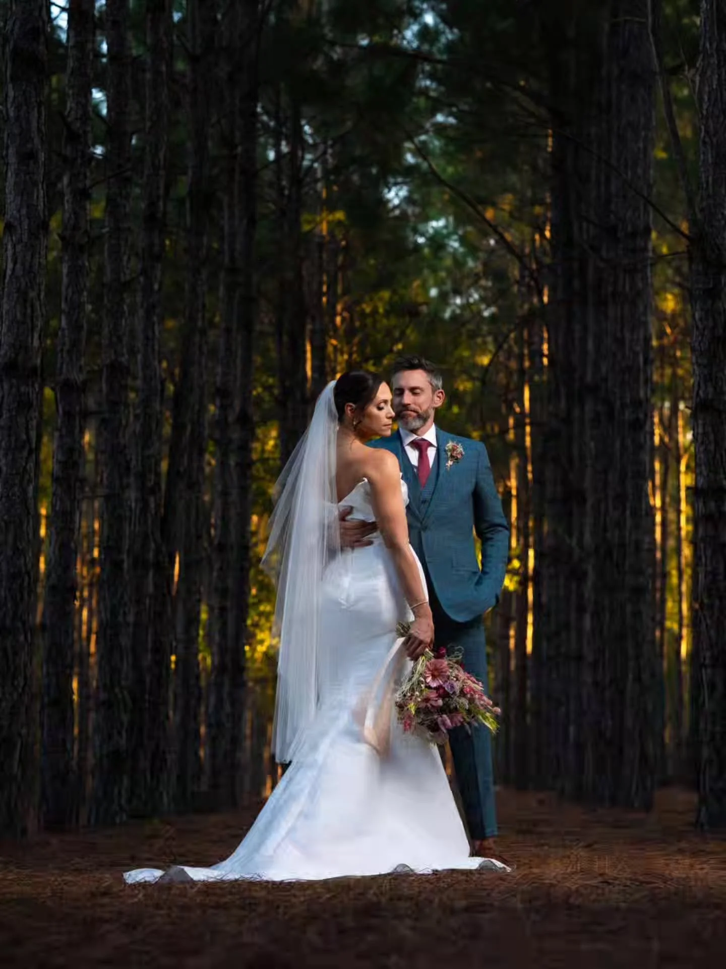 《 They slipped away just as the sun dipped low, surrounded by towering pines and that kind of light you only get once in a lifetime. He held her like the world had stopped spinning. Two hearts, one quiet moment, and a forest turned into their own lit