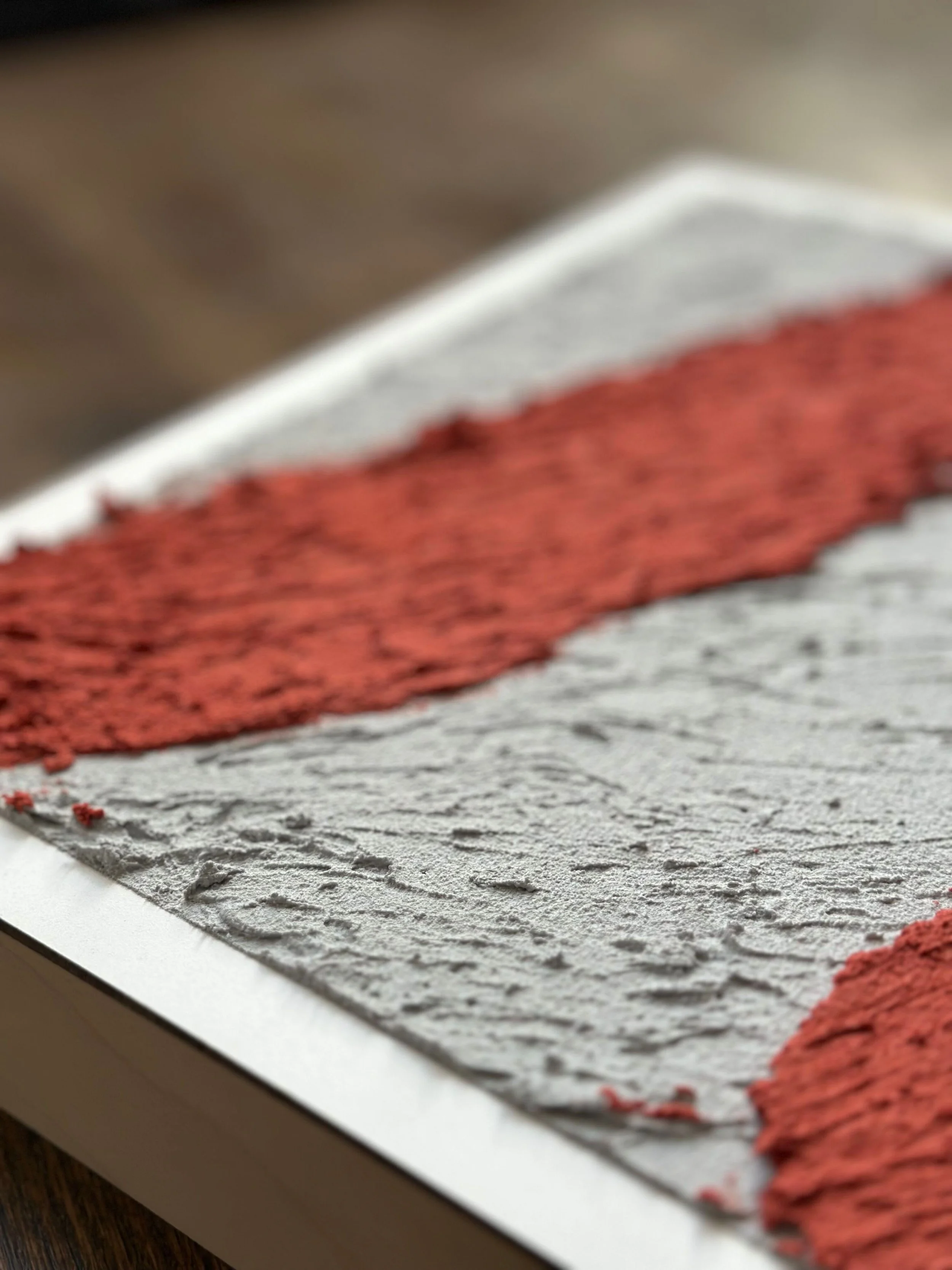 Close-up of textured surface with red stripes and gray background, possibly a painted or printed material.