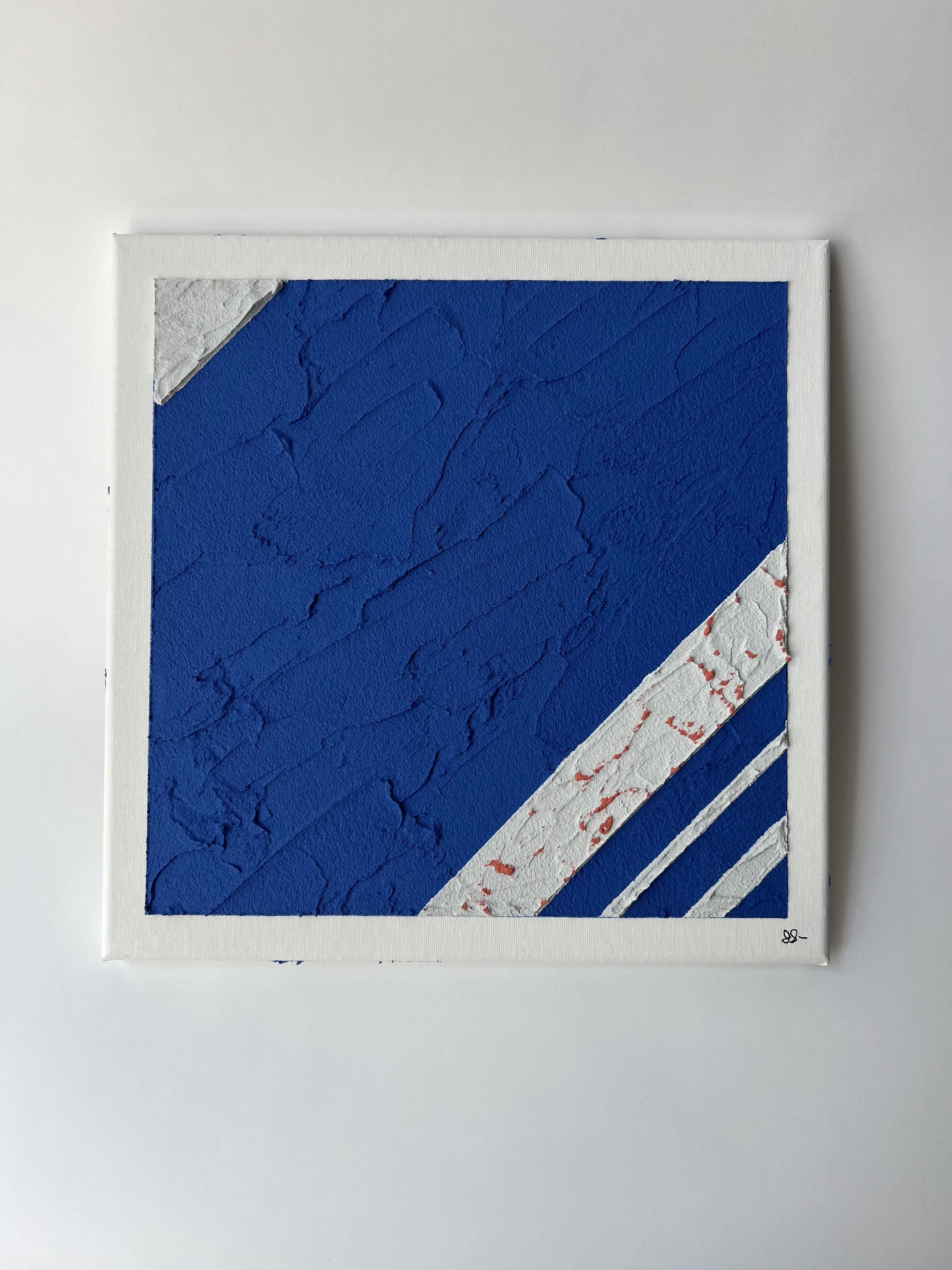 Abstract painting with large blue textured section, and smaller white textured sections with red accents, framed with a white border.