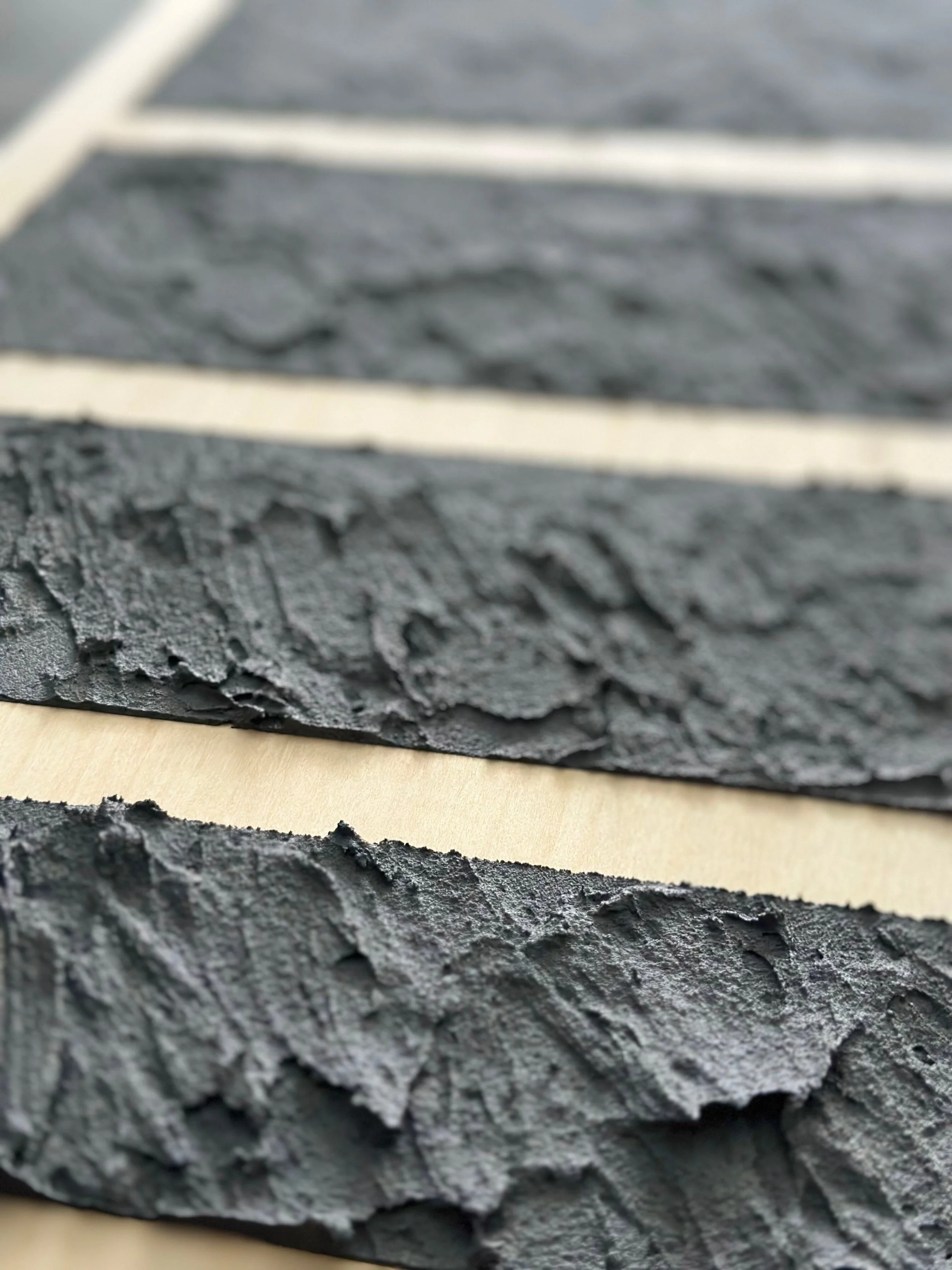 Close-up of textured, dark gray slate tiles with light-colored grout lines.