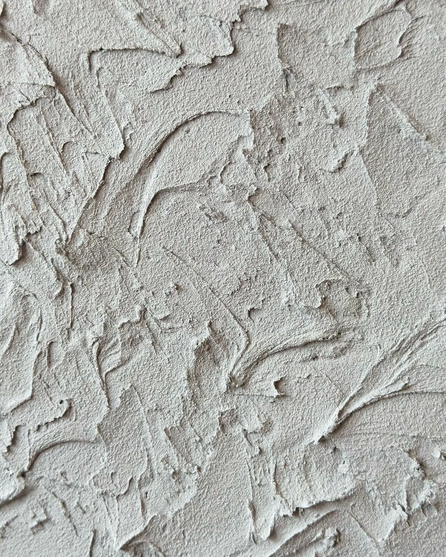 Close-up of a textured wall with cracked and peeling paint.