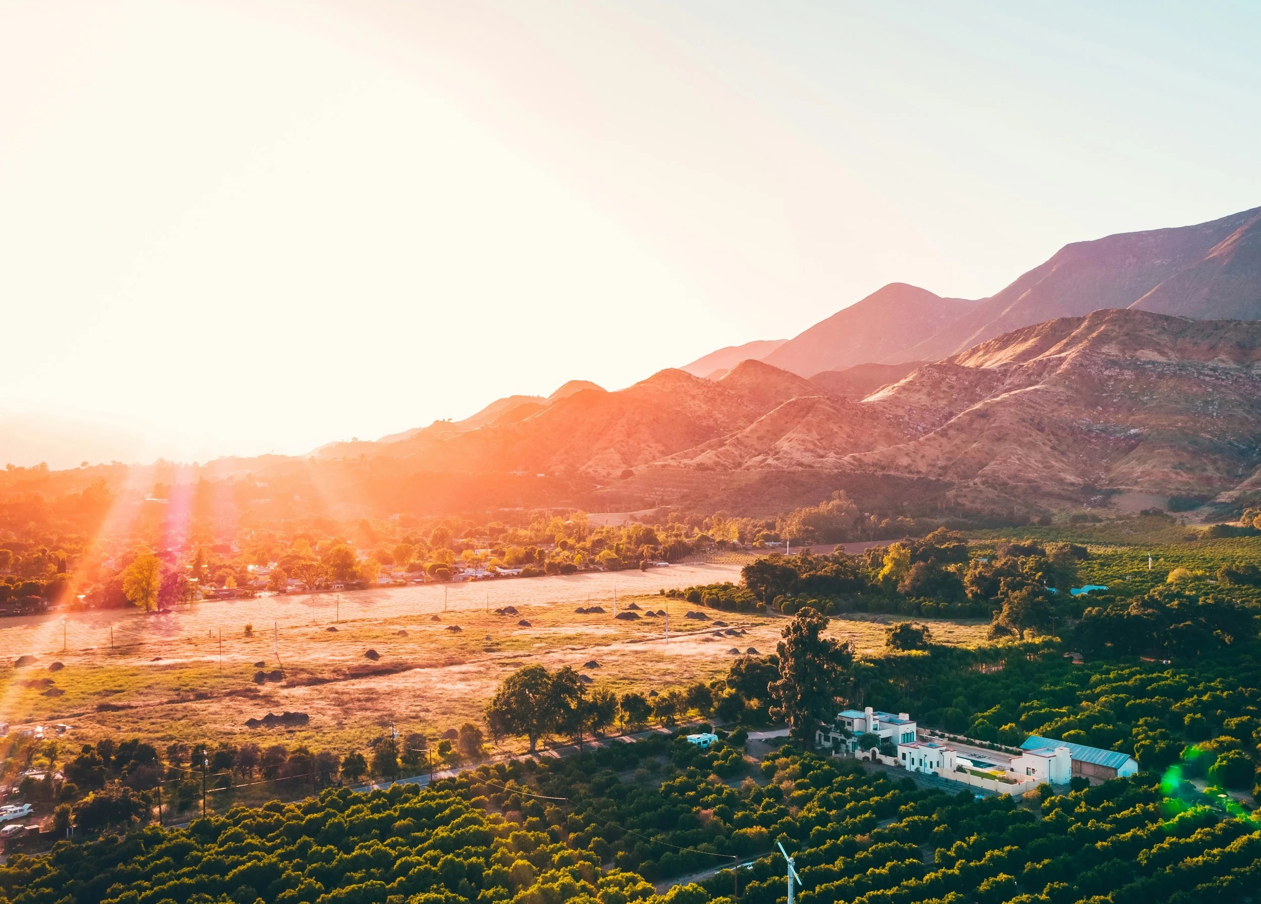 Sunset over mountains and valley with trees and houses in California