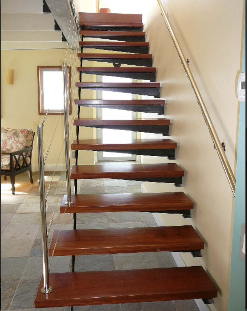 A modern staircase with wooden steps, metal railings, and a yellow wall, located in an indoor setting with tiled flooring.