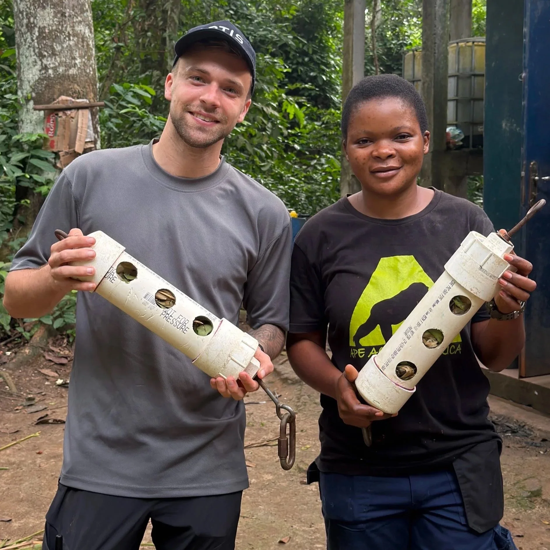 Boy Roeles and Zita holding enrichment pieces they have created together at Ape Action Africa's sanctuary in the Cameroon rainforest.