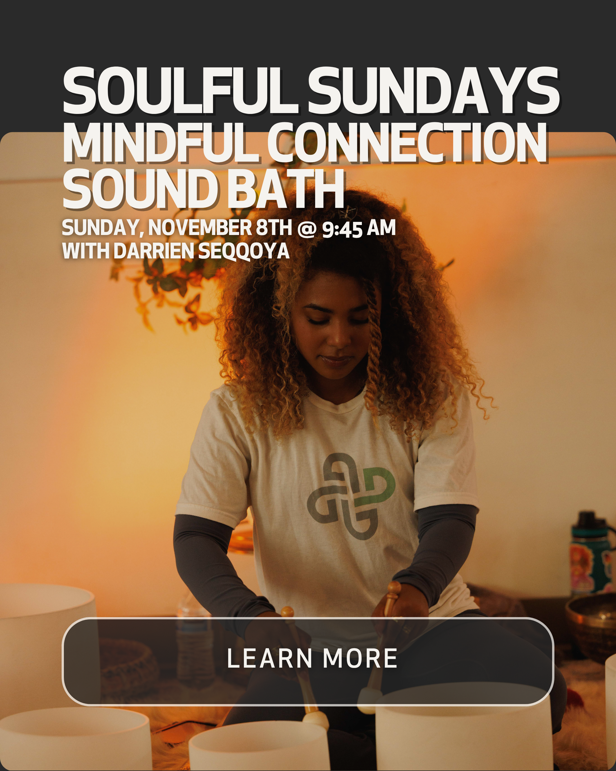 A woman with curly hair in a meditation or sound bath session, surrounded by singing bowls, in a calming indoor setting with warm lighting.