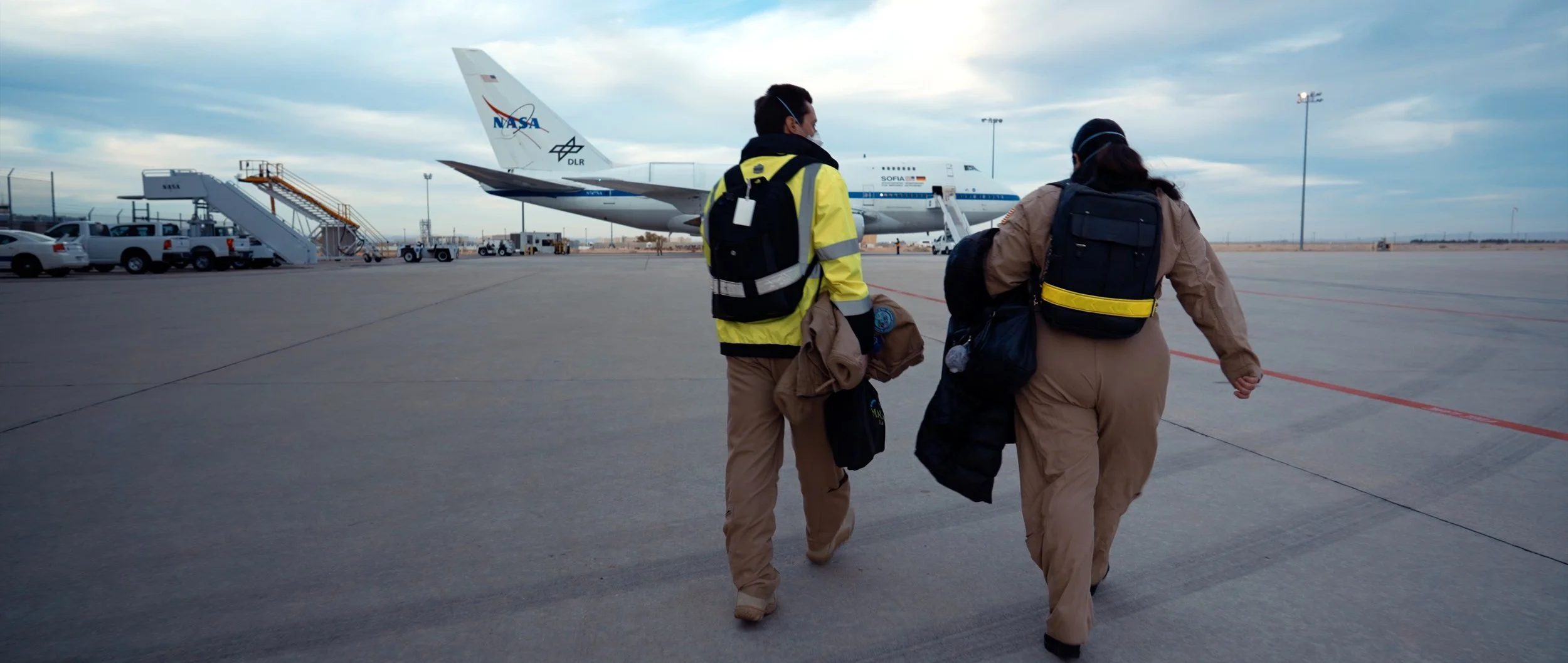 Crew walking to NASA's SOFIA observatory aircraft on the runway