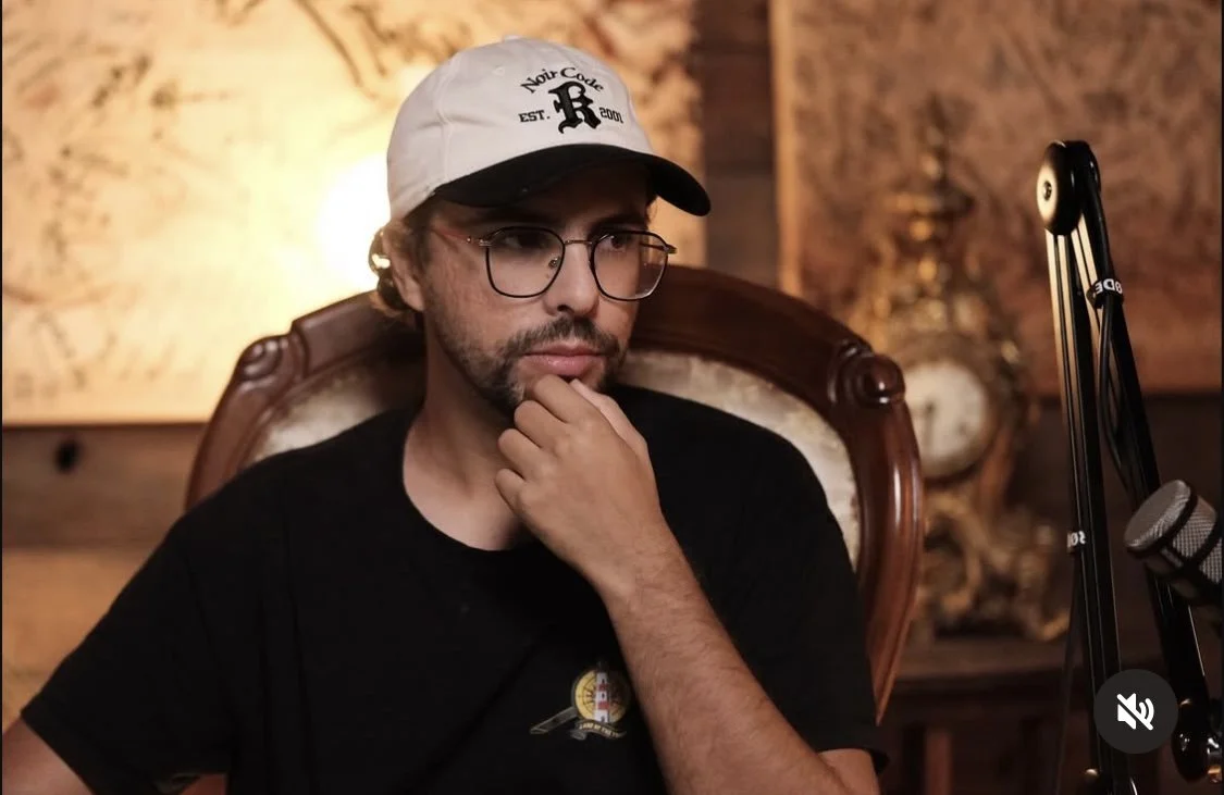 People riding and waiting for scooters on a city street at night, some wearing helmets and backpacks.