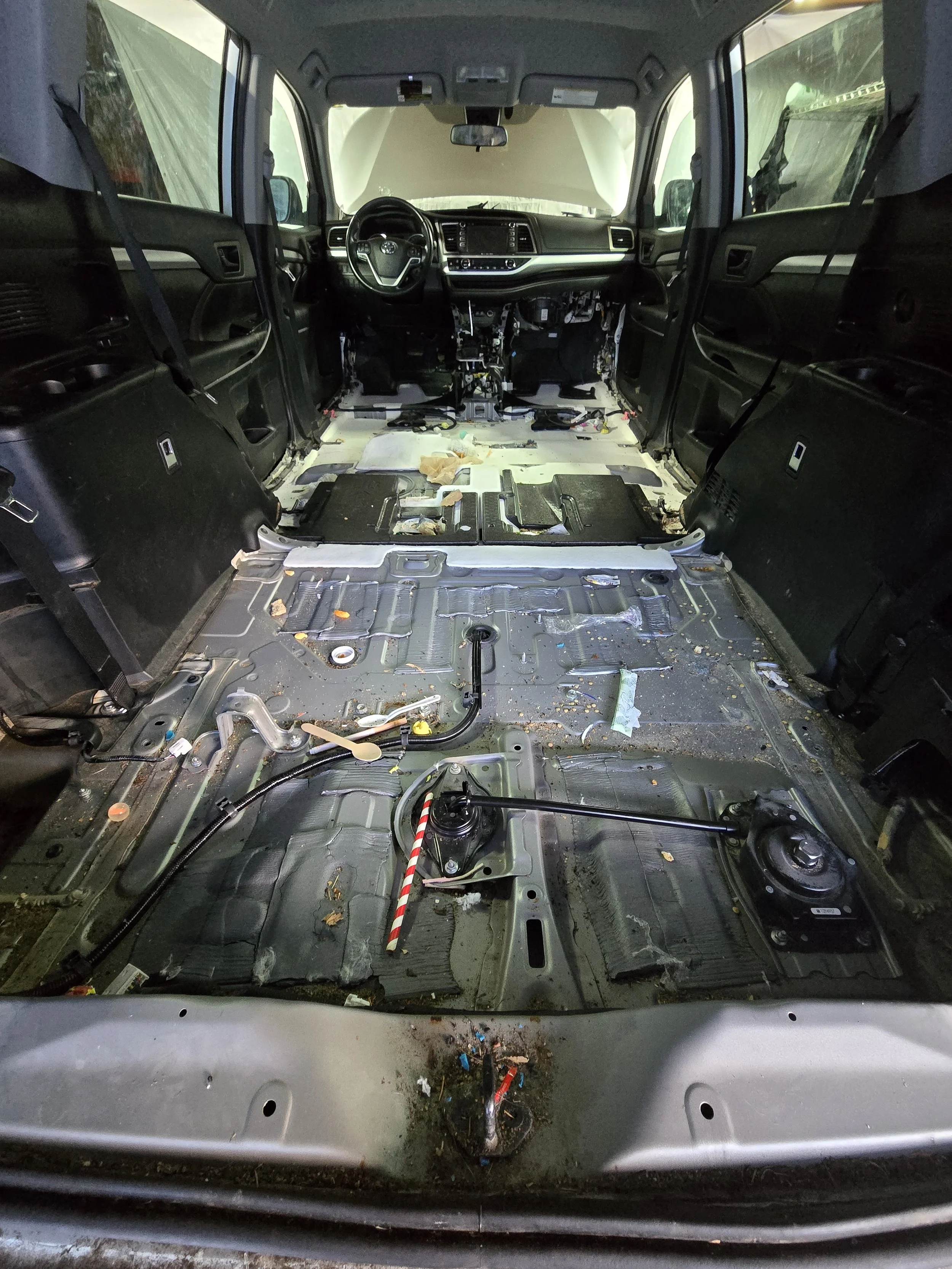 Interior of a vehicle with seats removed as part of a professional automotive interior service process.