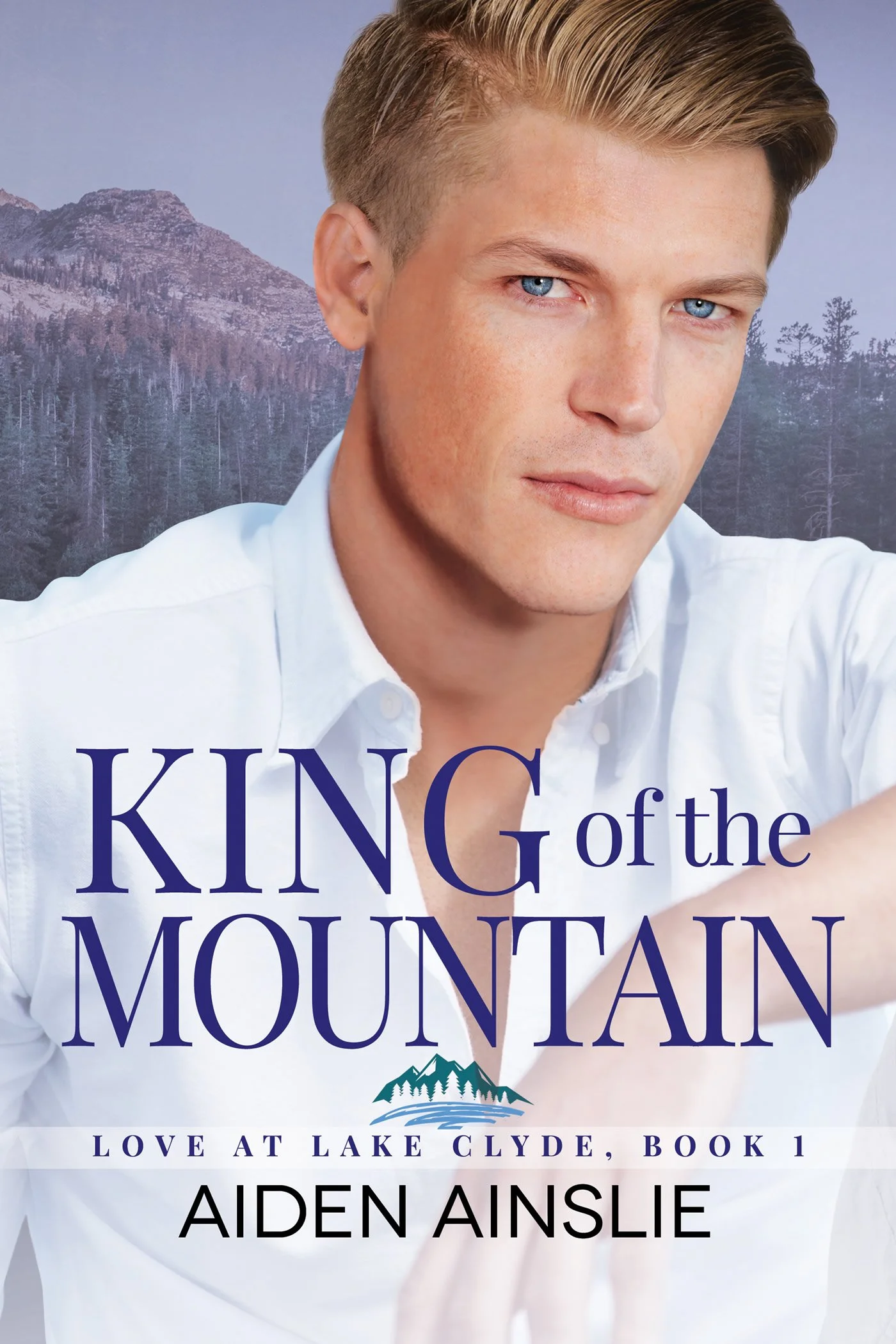 Close-up of the book cover for 'King of the Mountain' by Aiden Ainslie, featuring a man with fair skin and blue eyes wearing a white shirt, with a mountain background and the subtitle 'Love at Lake Clyde, Book 1'.