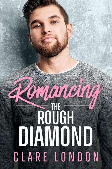 A young man with a beard and short hair standing against a gray textured wall, wearing a gray sweater, with the title "Romancing the Rough Diamond" and the author's name "Clare London" displayed on the image.