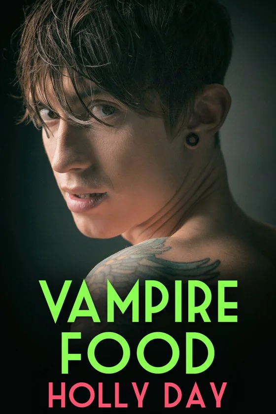 A young man with dark hair, wearing a black earring, looking over his shoulder, showing a tattoo on his shoulder, with the title 'VAMPIRE FOOD HOLLY DAY' in bold green and pink letters.