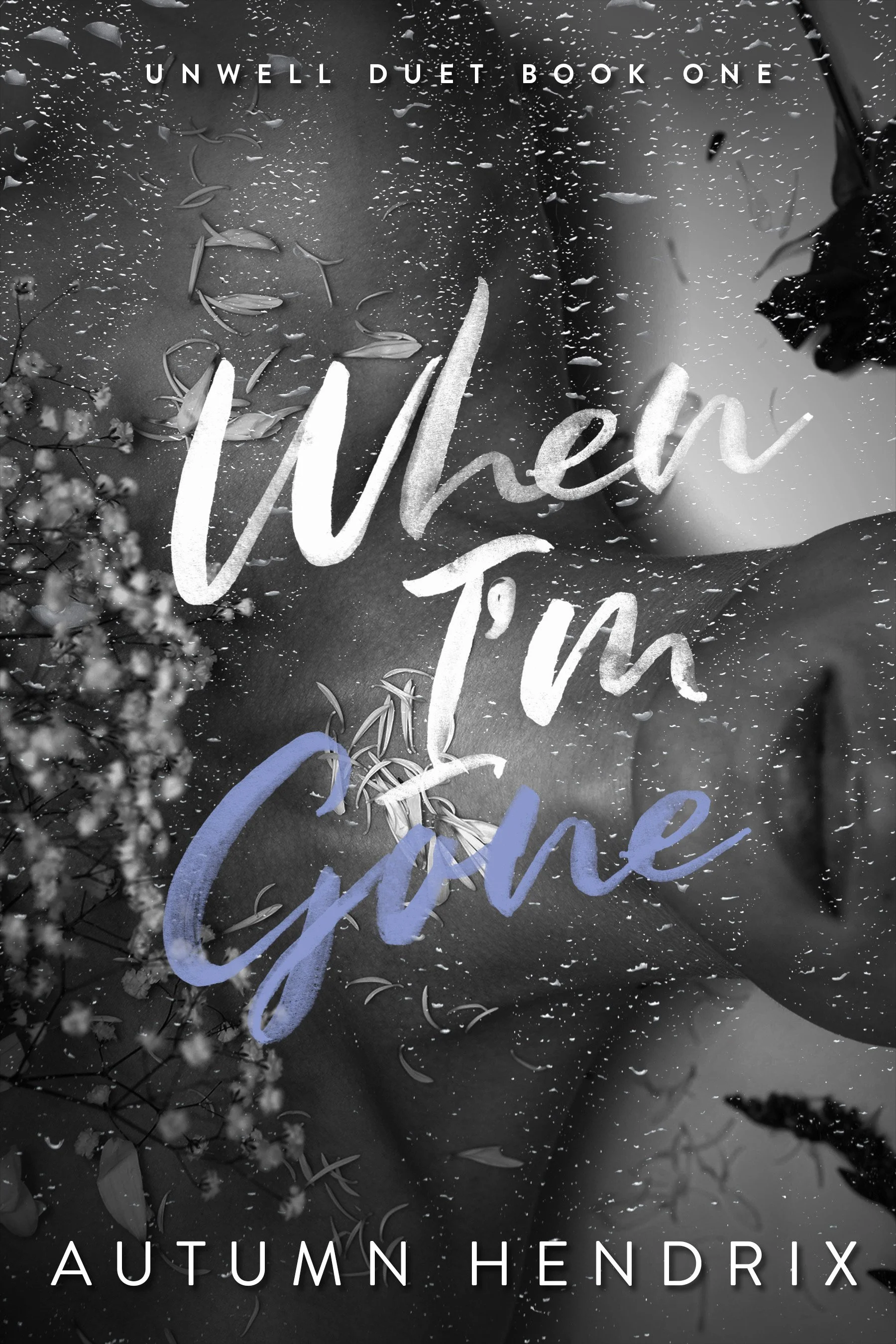 Black and white photo of a book cover titled 'Unwell Duet Book One' by Autumn Hendrix. The title text 'When' is written in large, cursive font across the cover. The background features a dark, textured surface with scattered leaves and flower petals.