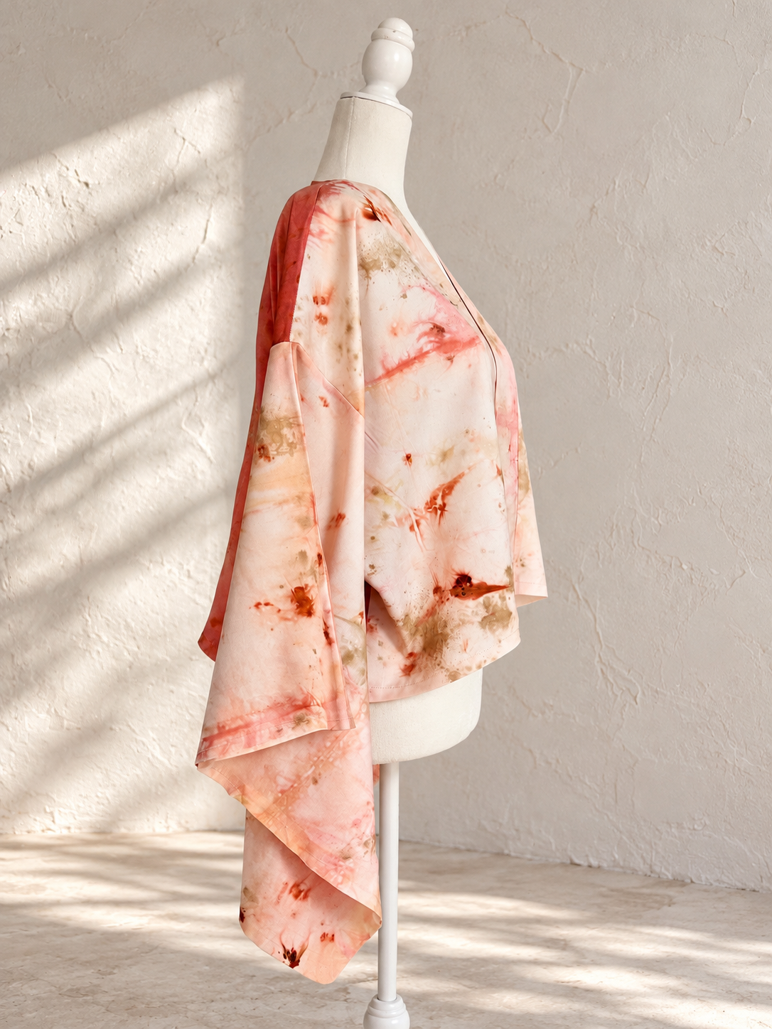 One-of-a-kind cropped silk kimono jacket by Flora Obscura, shibori-dyed with peach annatto and eco-printed with sulfur cosmos and oak gall, featuring a madder-dyed silk charmeuse back panel printed wi