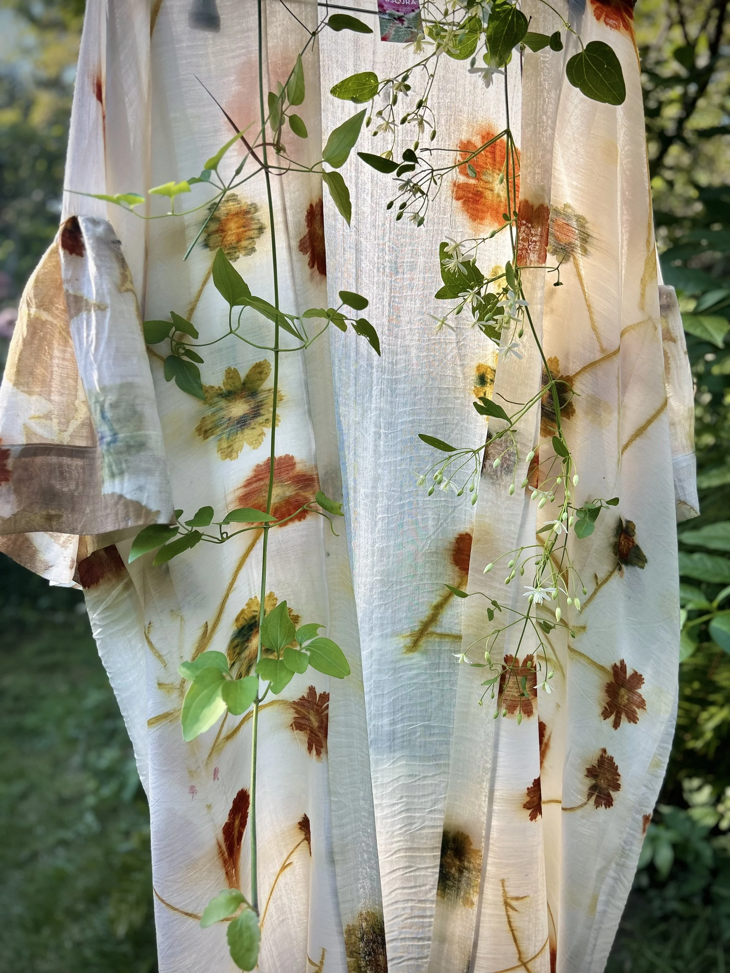 Golden yellow and orange coreopsis flower imprints with subtle grey-green shadows.