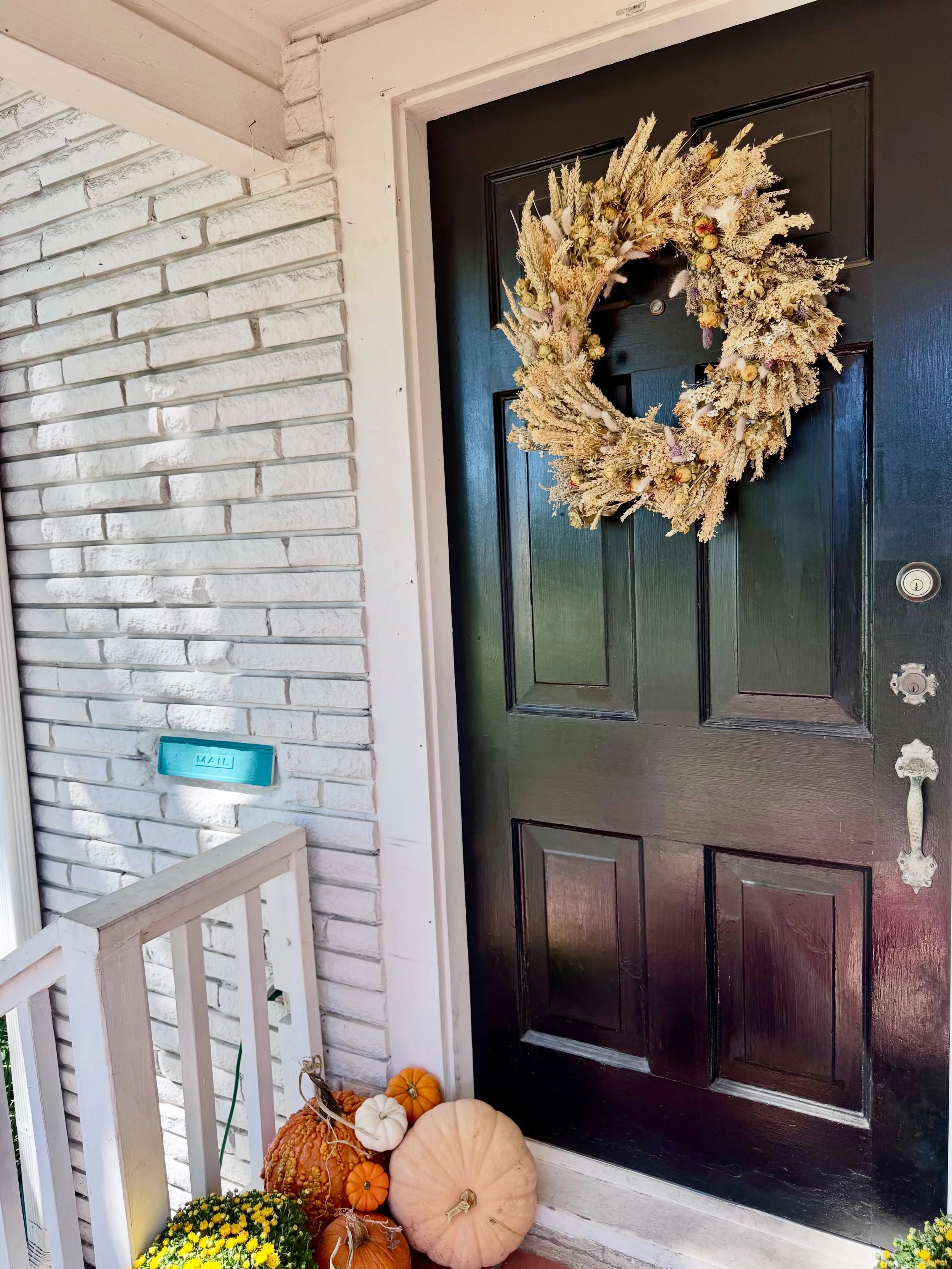Fall feels right at home here. 🍂 A mix of dried greenery, earthy tones, and natural texture brings a little warmth to the front porch.
