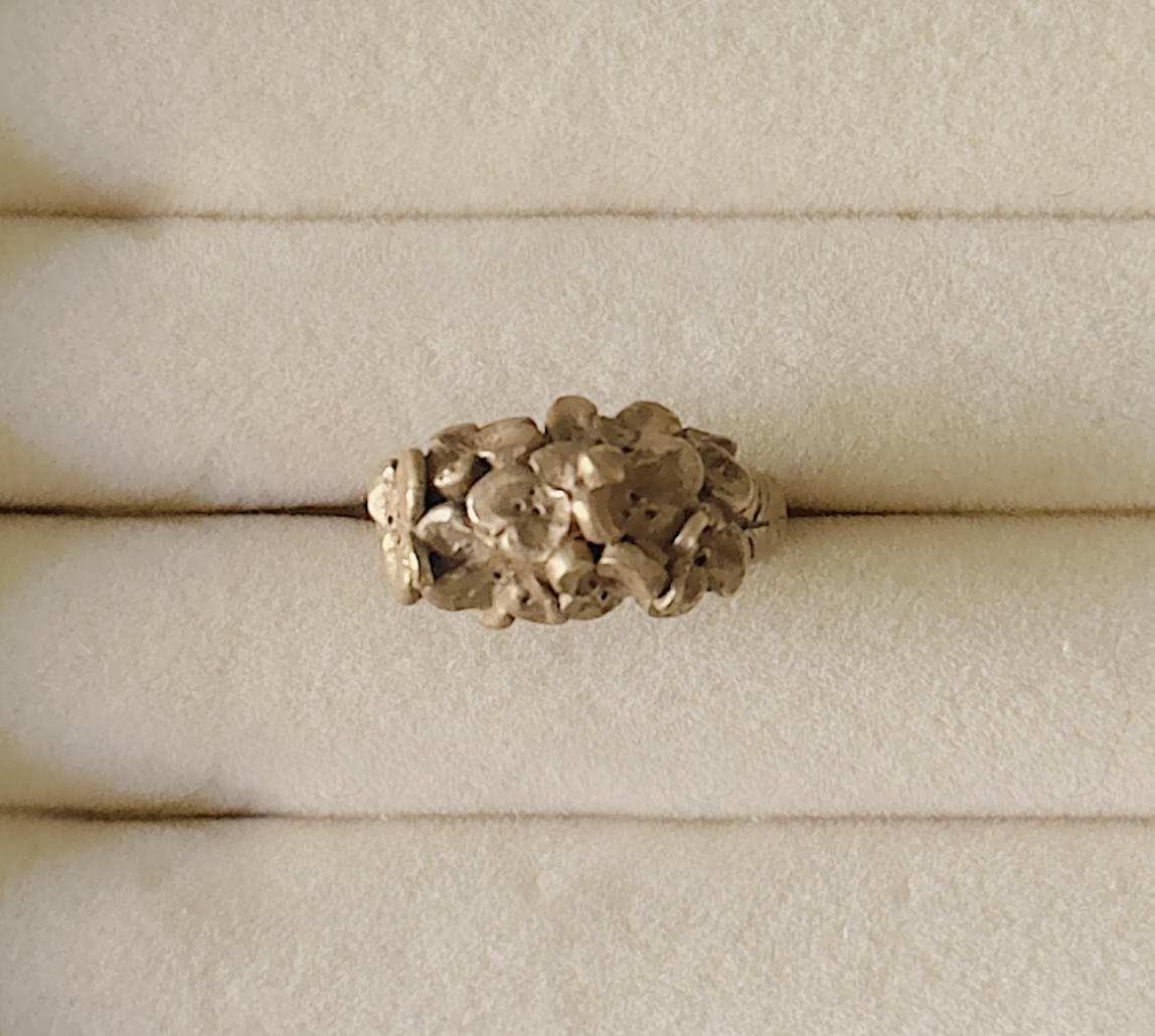 Close up, top down photo of a bronze clay crafted ring in the shape of a hydrangea.