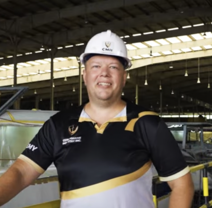 Young man with glasses wearing a hoodie and blue shirt in an indoor setting.
