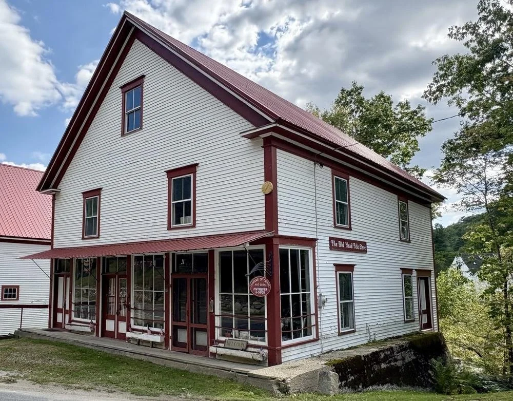 The Head Tide Store, photograph September 2025, with red trim and a hanging sign