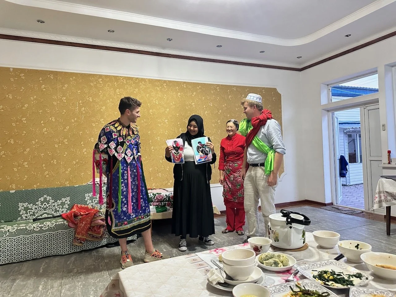  No women volunteered so we had one of the men dressed in the bride’s wedding customer (left). The groom wears two sashes crossed over his chest. These wedding clothes are from the host’s niece, and the dress that she’s wearing (the red dress that lo