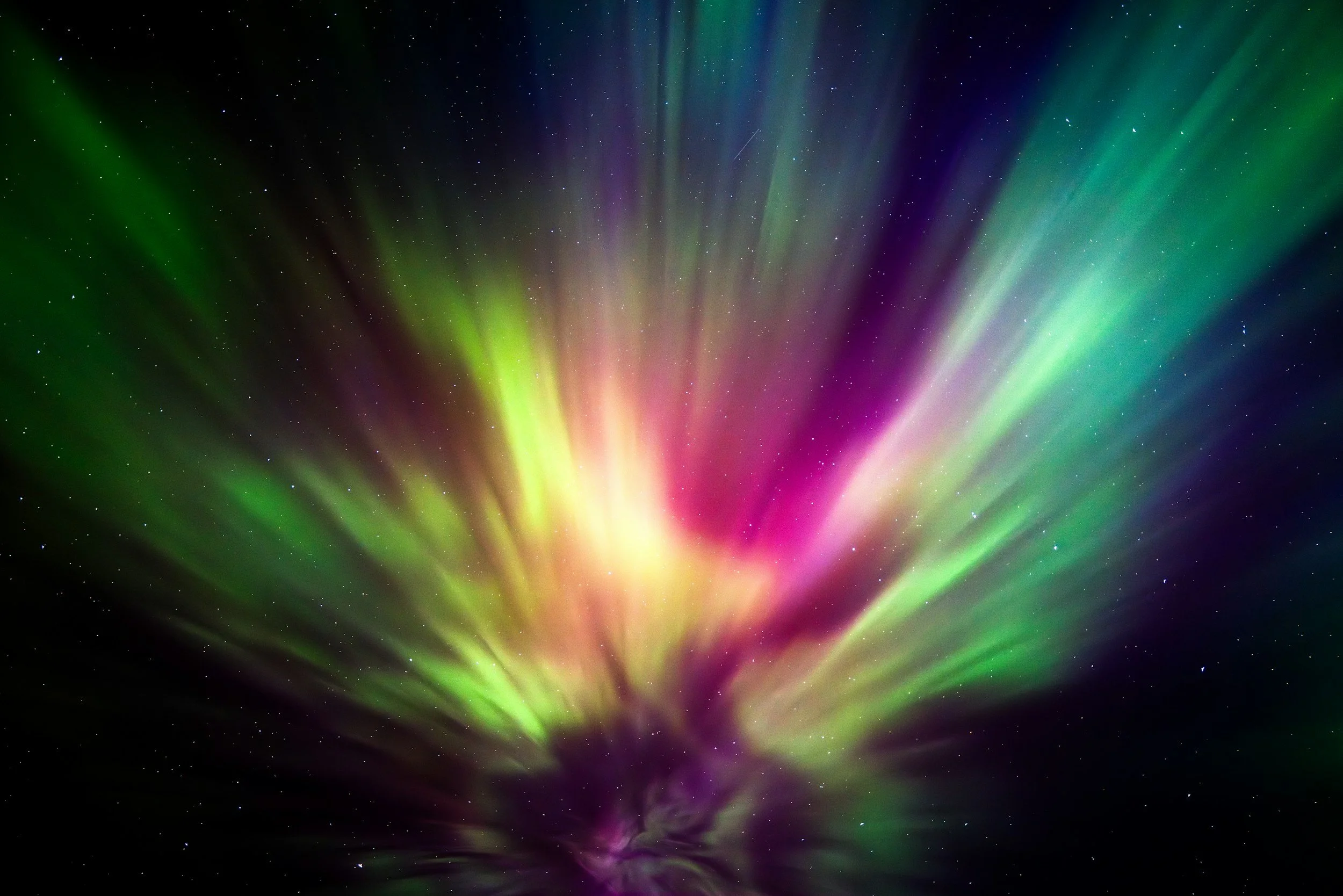 Northern lights displaying green, pink, and purple colors across a starry night sky.