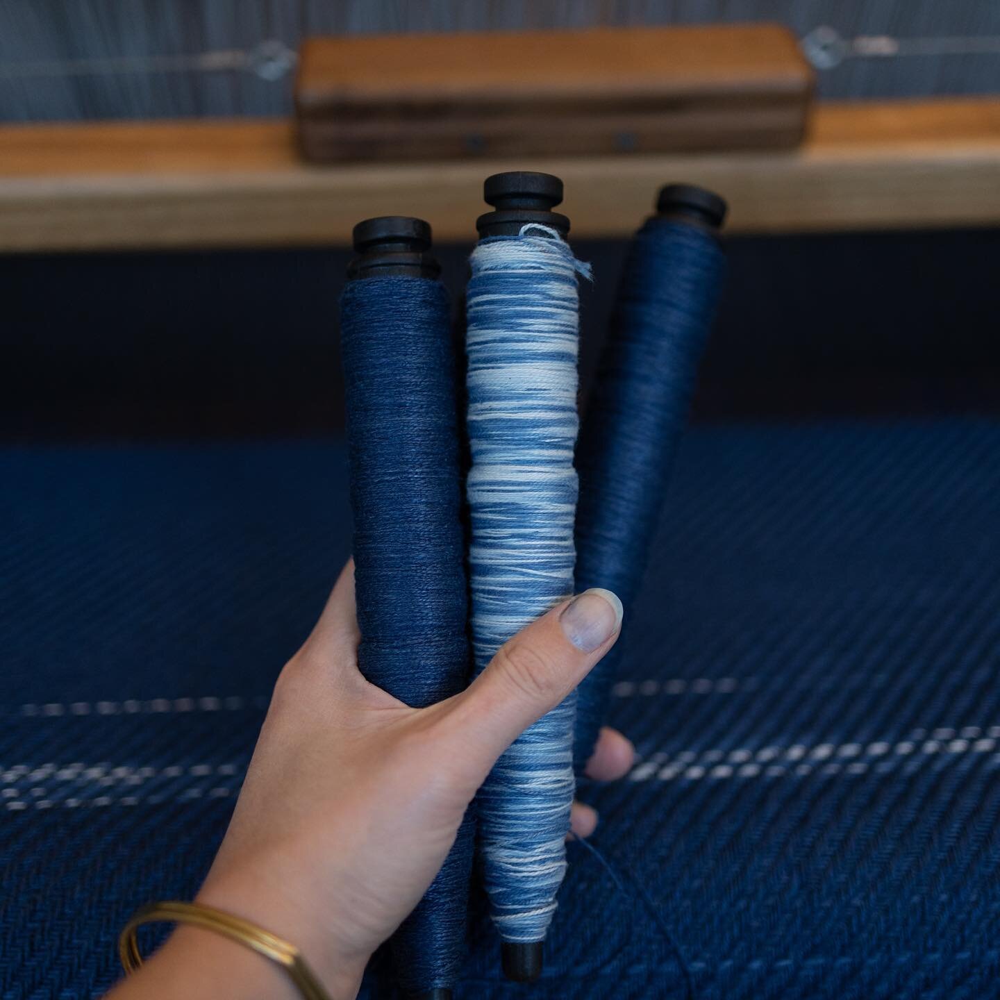 Bobbins &bull; Hand dyed organic cotton combined with blue linnen. I dyed these yarns a while back in our garden using my indigo vat. Now i am finally getting to weave with them and discover the patterns they make in the cloth. A technique loosely re