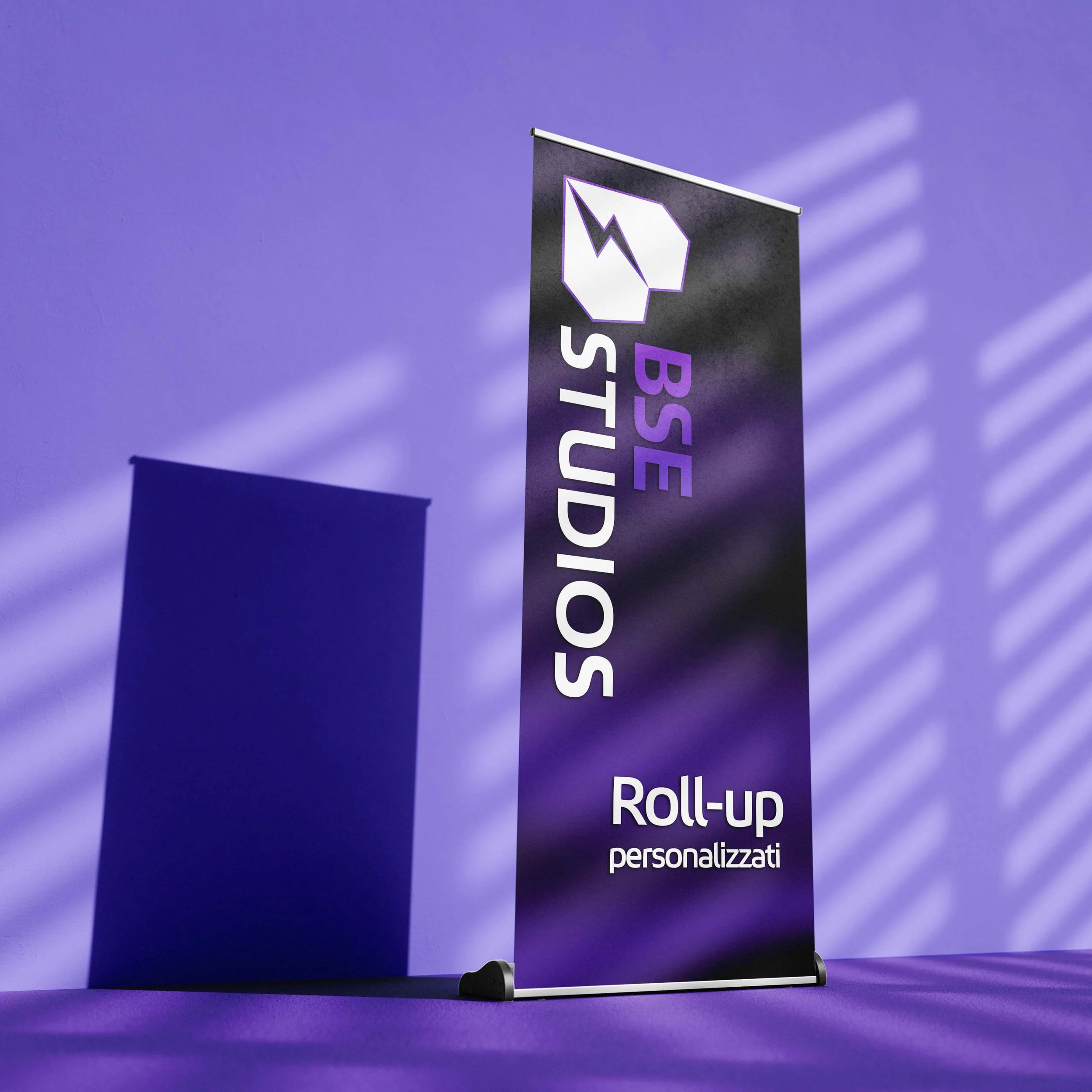 Piano pubblicitario a bandiera blu con slogan 'BSE STUDIOS' e 'Roll-up personalizzati' su sfondo viola, con effetti di luce e ombre.