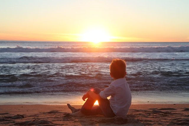Boy on beach at sunset