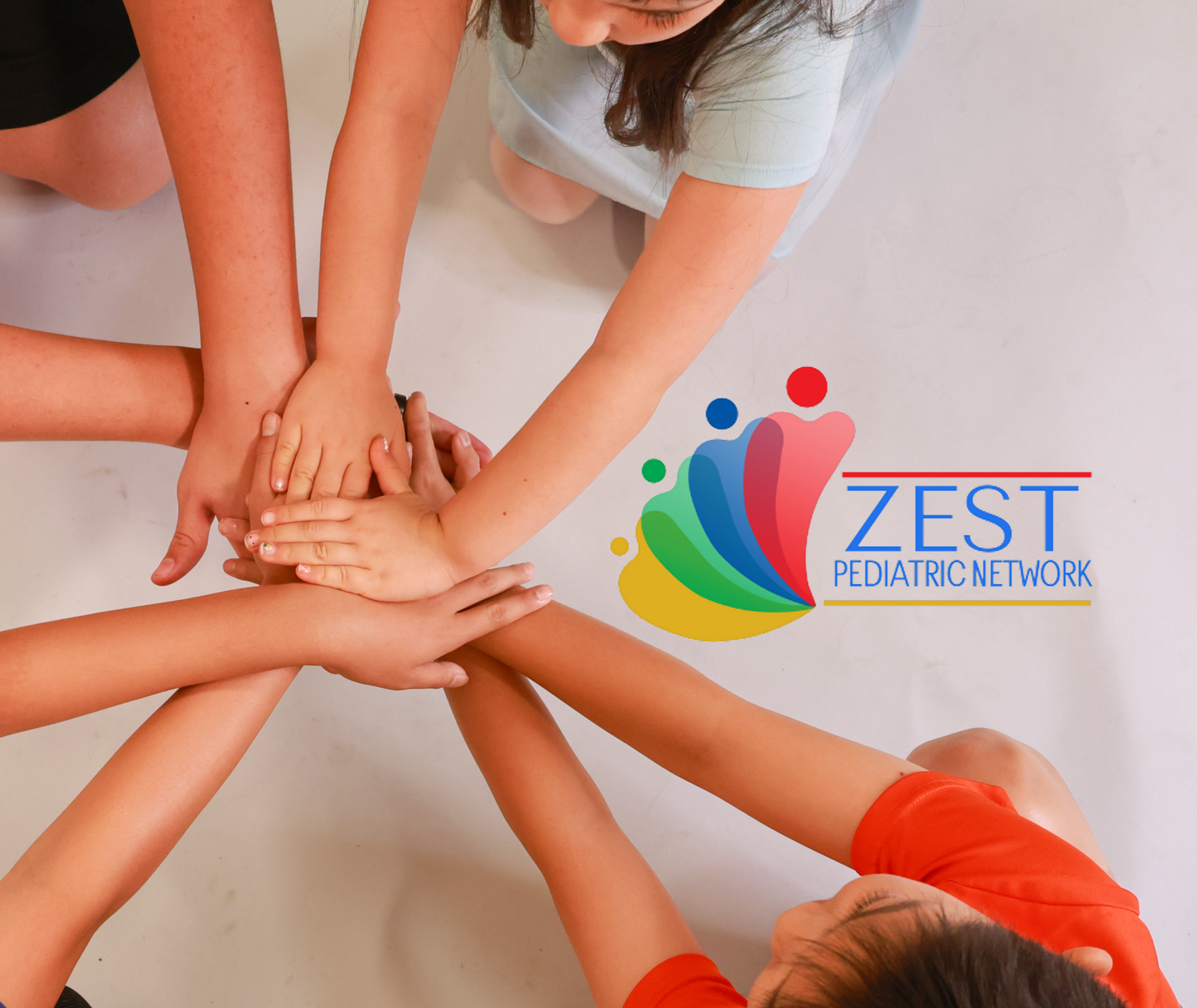 Multiple people placing their hands together in a circle, showing unity and teamwork.