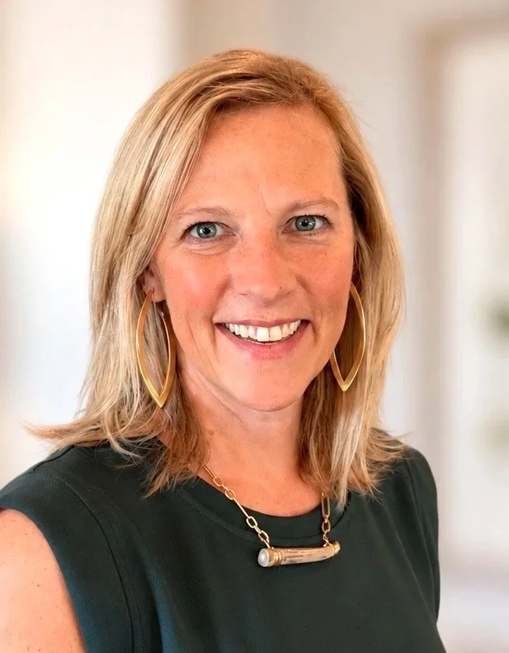 A smiling woman with blonde hair standing with her arms cross - Dr. Rachel Dawkins
