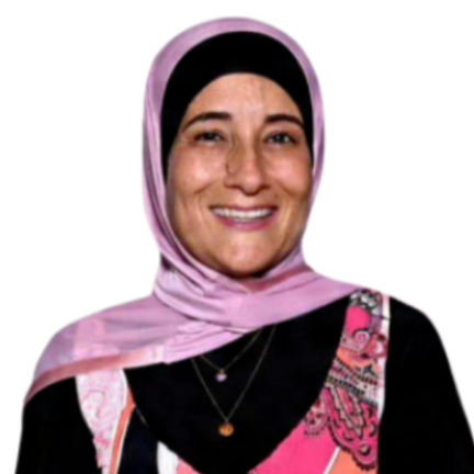 Head and shoulders portrait of a young woman with long brown hair and a friendly smile, wearing a patterned top with green and blue accents.