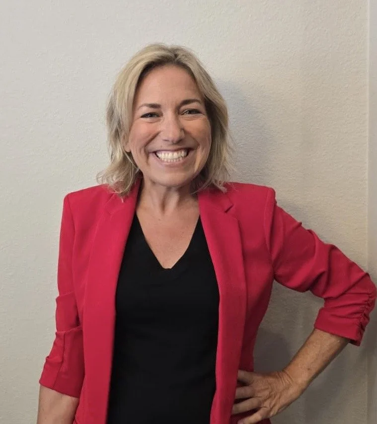 A smiling woman with blonde hair standing with her arms cross - Dr. Rachel Dawkins