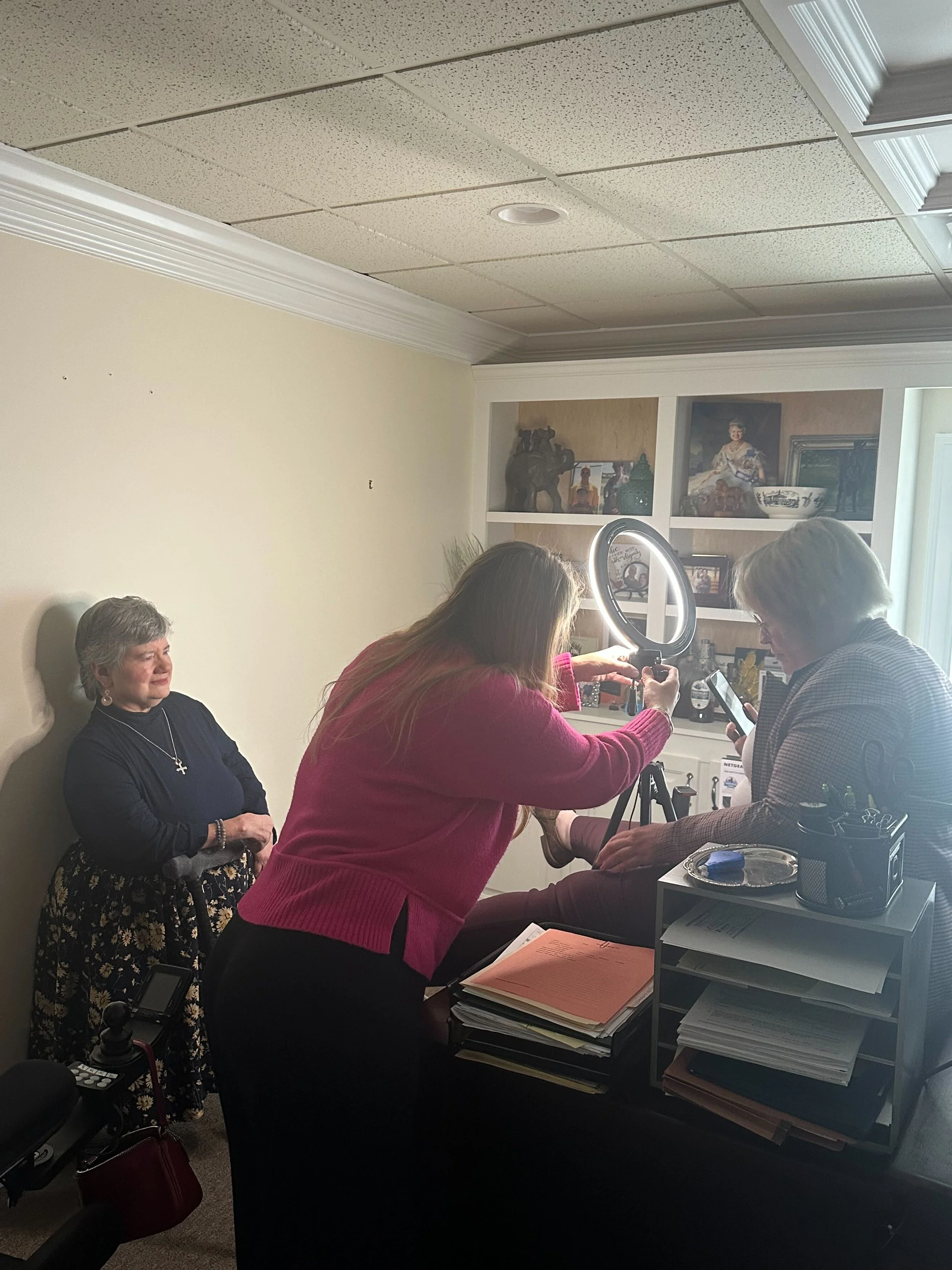 It's a team effort to take Amy's passport picture.