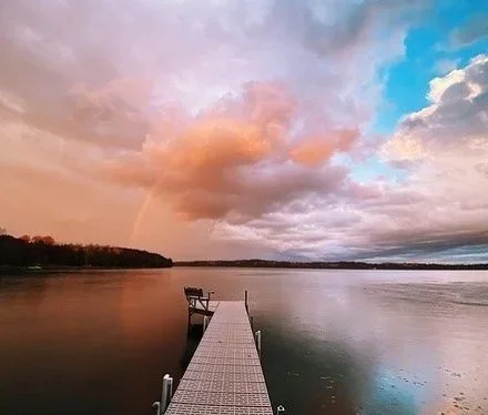 Wooden dock extending into calm Island Lake at sunrise near Spooner WI.
