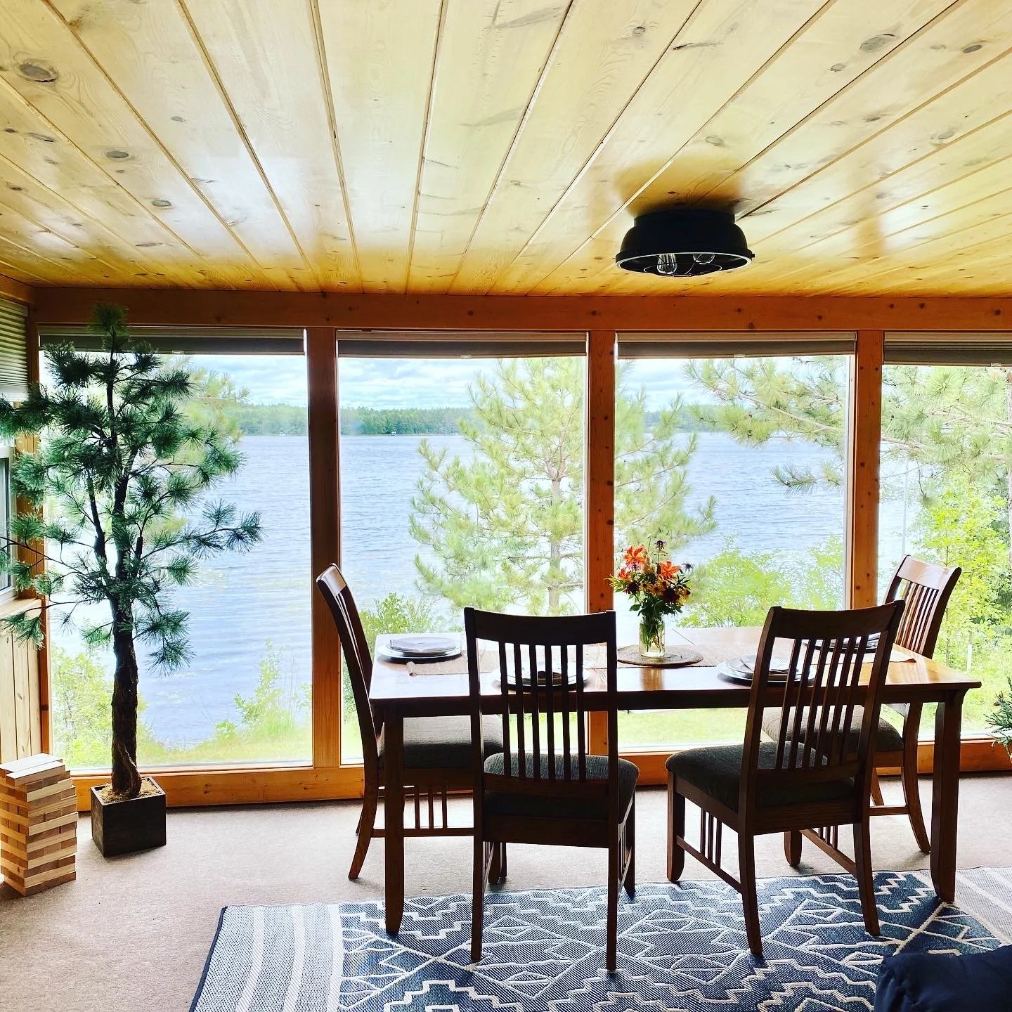 Dining table set in front of large windows overlooking Island Lake.