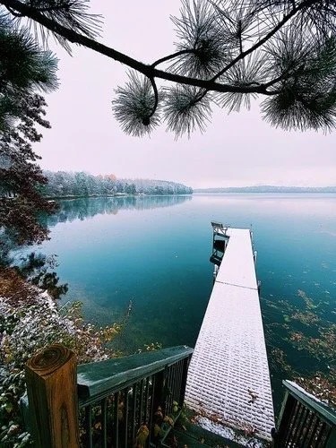 Snow-covered dock extending onto frozen Island Lake in winter.