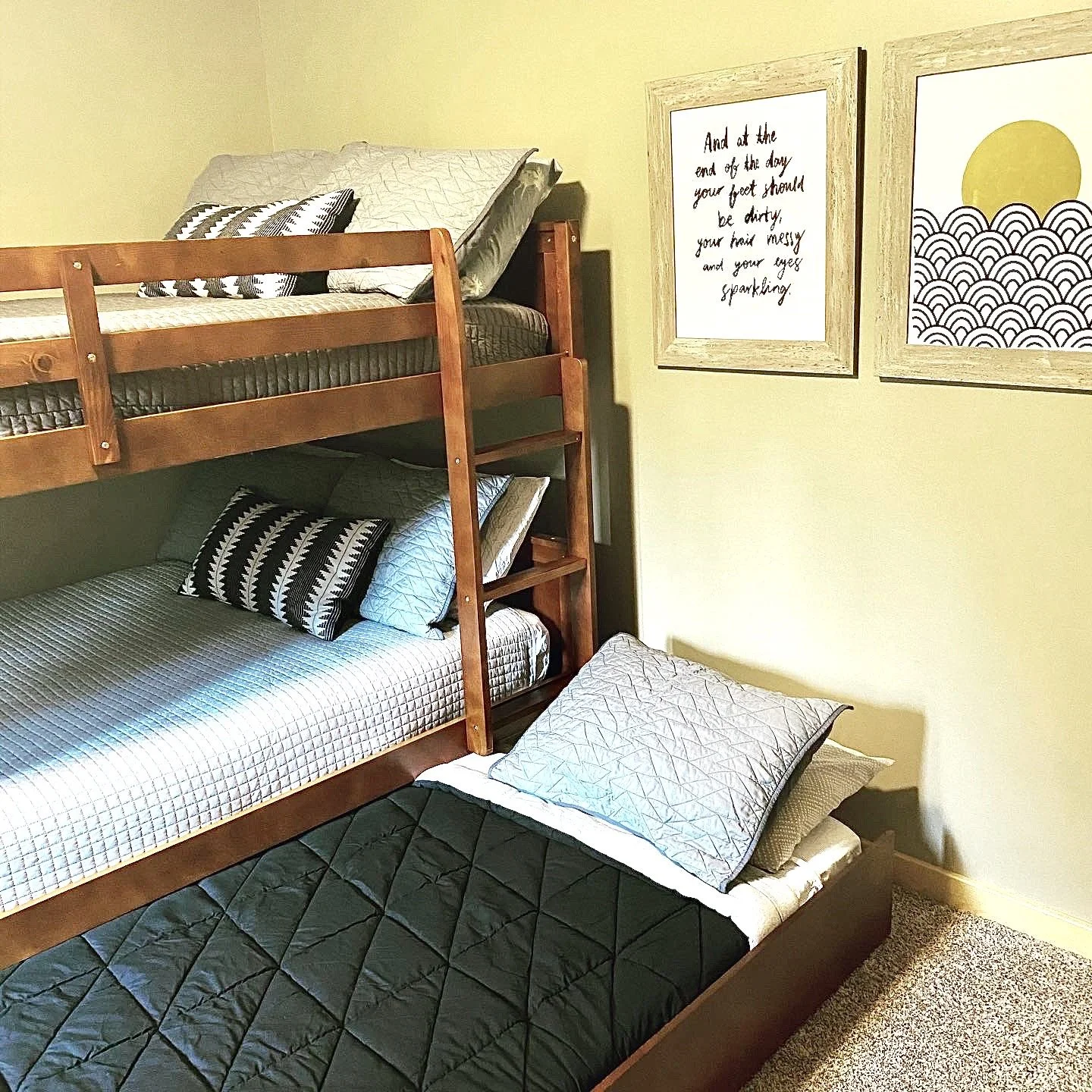 Cozy cabin bedroom with wooden bunk beds and trundle bed.
