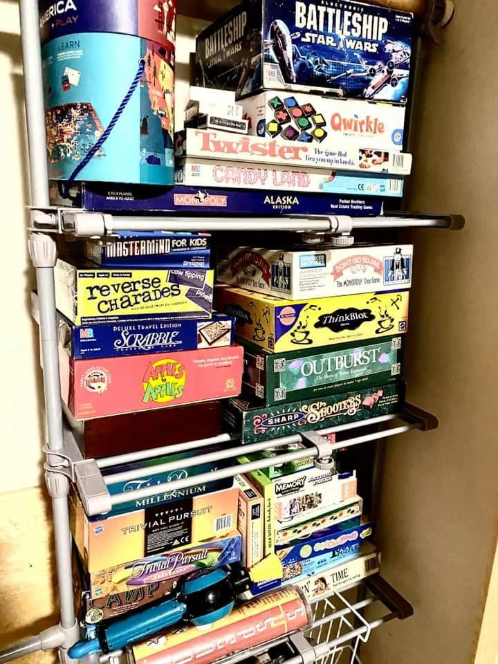 Shelf stacked with family board games inside Island Lake cabin.