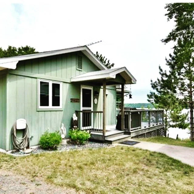 Side exterior of Island Lake cabin with covered porch and seating area.