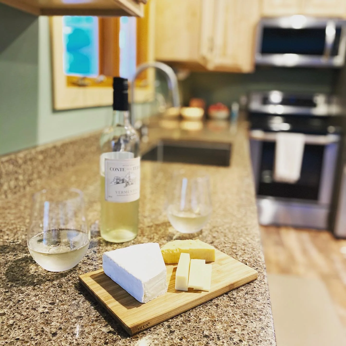 Wine and cheese on counter with kitchen in background at Island Lake cabin.