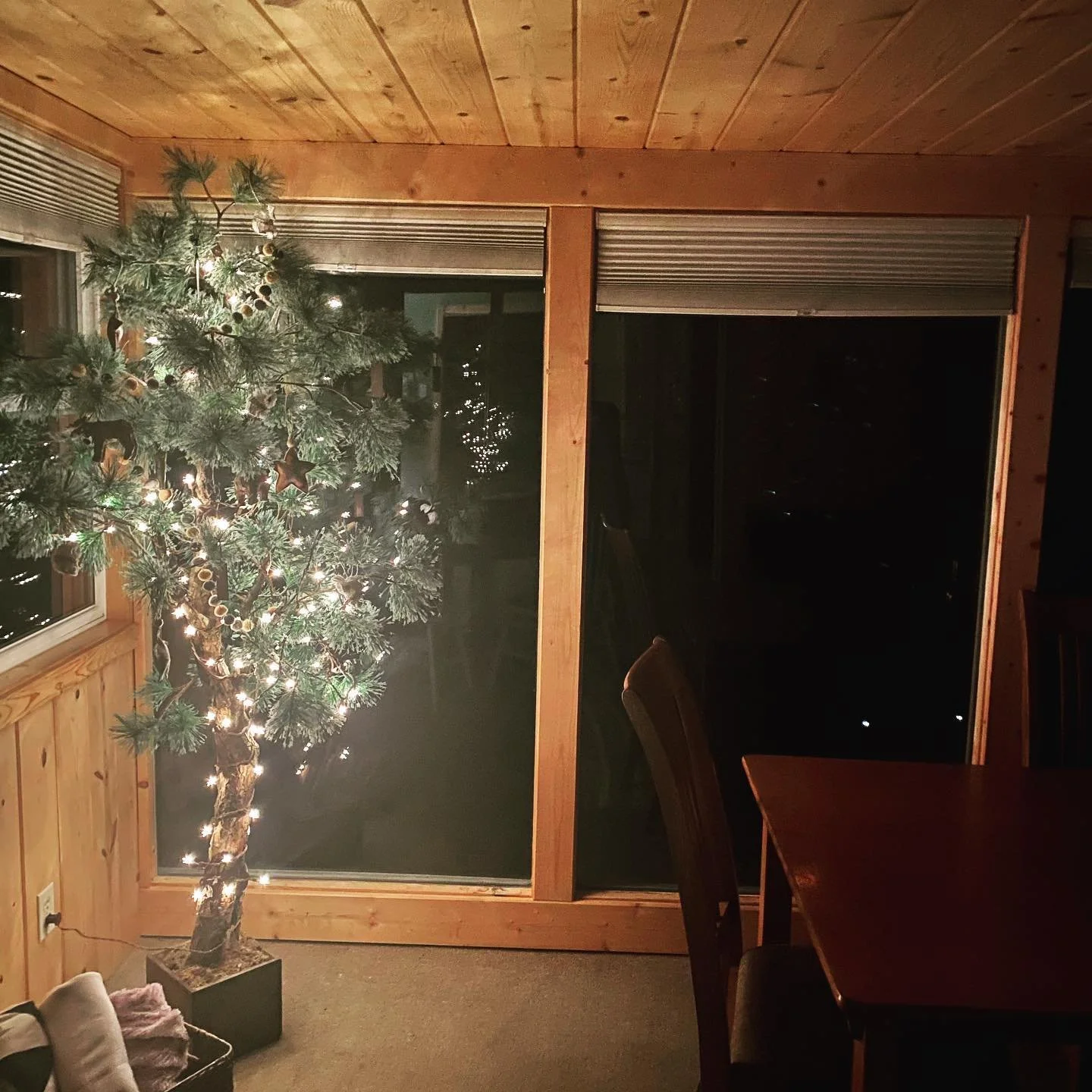 Cabin living room with cozy lighting and holiday tree near Island Lake.