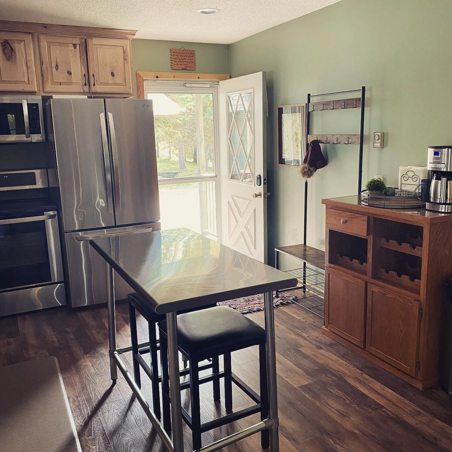 Modern cabin kitchen with stainless steel appliances and wooden cabinetry.