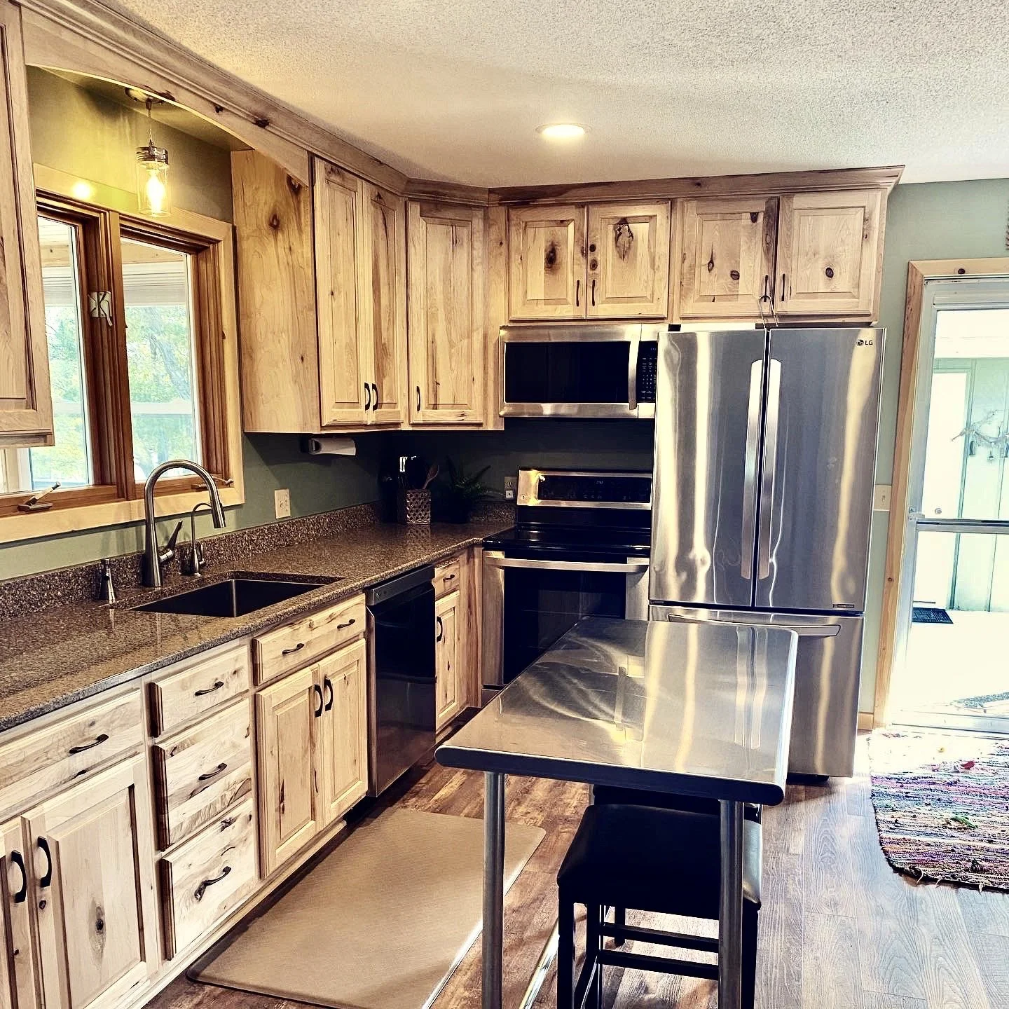 Island Lake cabin kitchen with stainless steel fridge and wooden cabinetry.