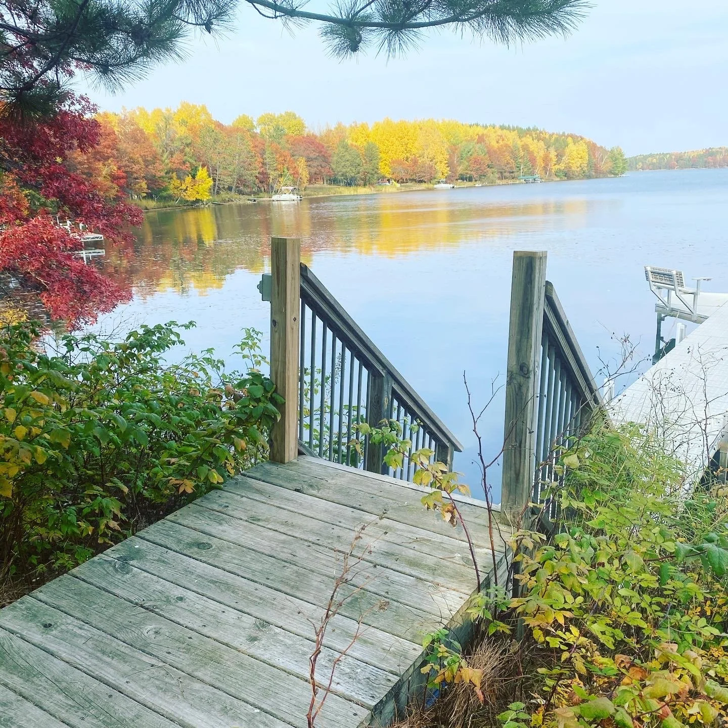 Dock on Island Lake surrounded by vibrant autumn trees near Spooner WI.