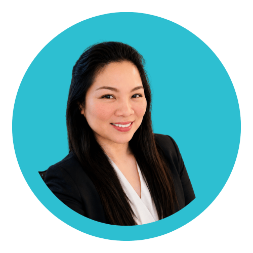 A professional woman with long dark hair smiling, dressed in a black blazer and white blouse, against a blue circular background.