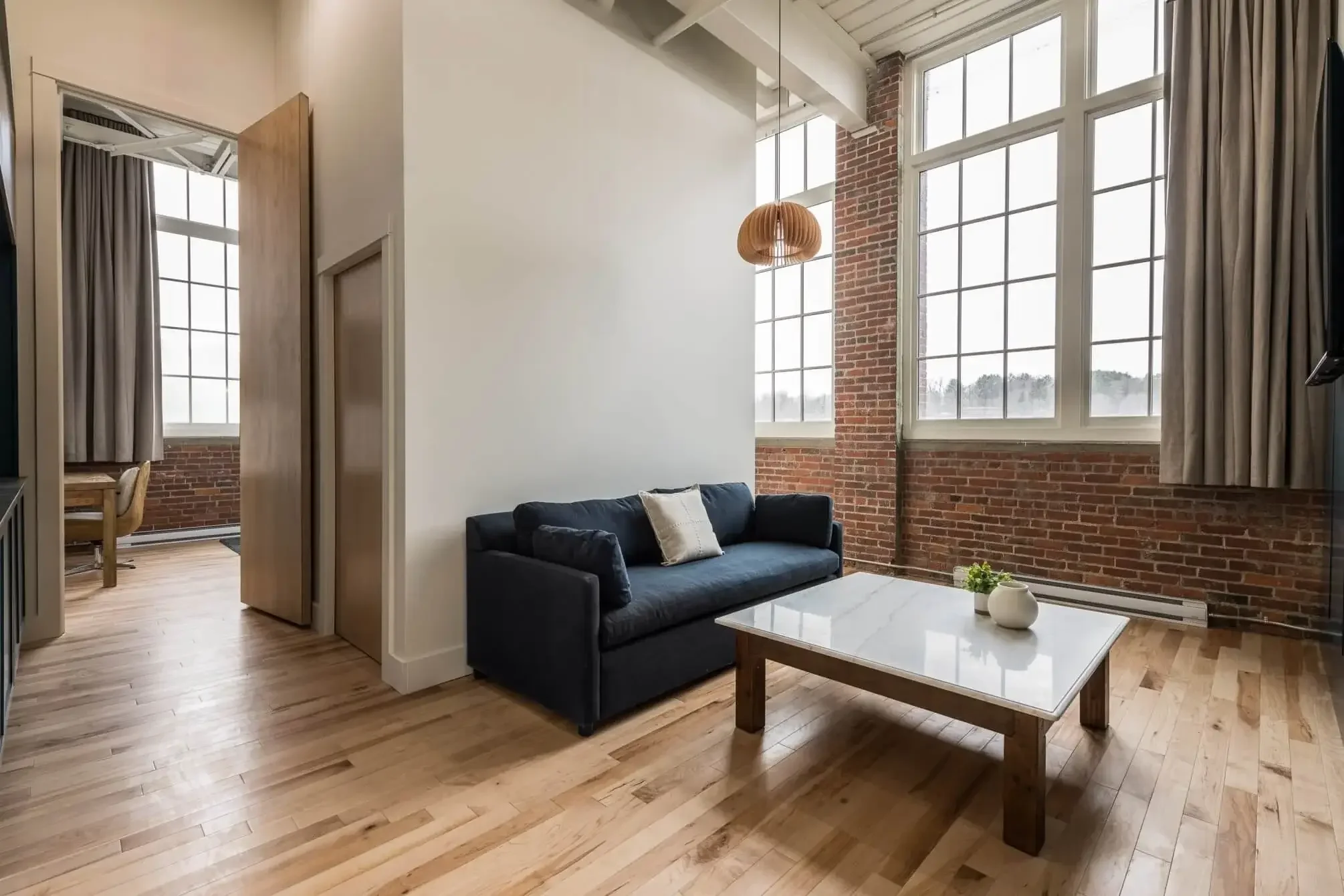 King room with wood floors and high ceilings at The Skowhegan boutique hotel