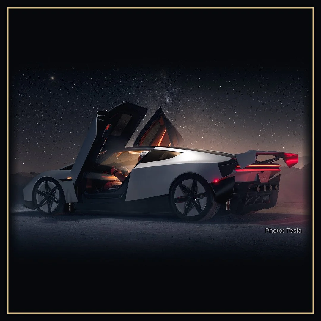 A Tesla Roadster with both gull-wing doors raised under a starry night sky. Photo: Tesla.